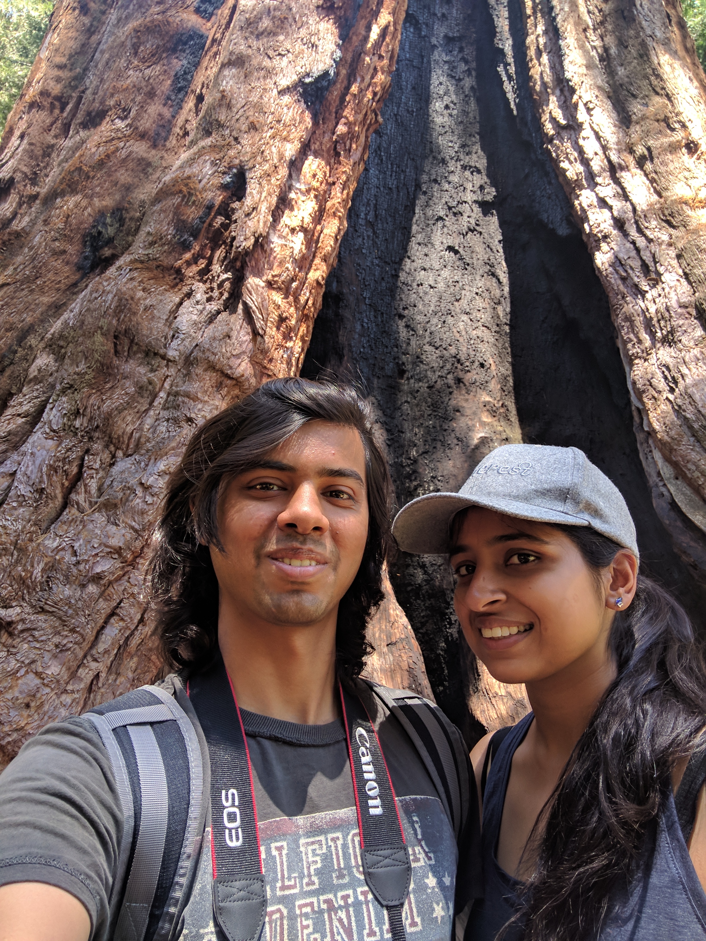 Selfie in front of a giant sequoia tree trunk
